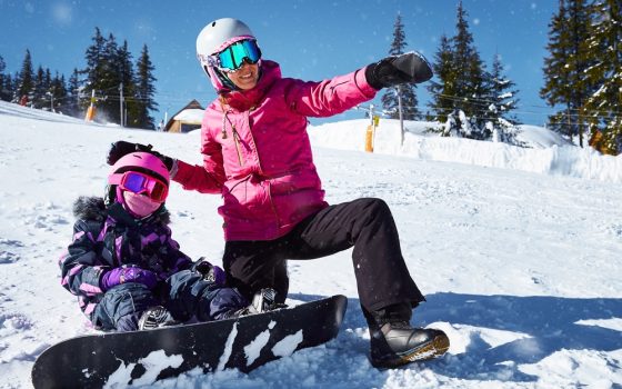 Mother,Teaches,His,Daughter,To,Snowboard.,Woman,Sits,And,Showing Mother,Teaches,His,Daughter,To,Snowboard.,Woman,Sits,And,Showing